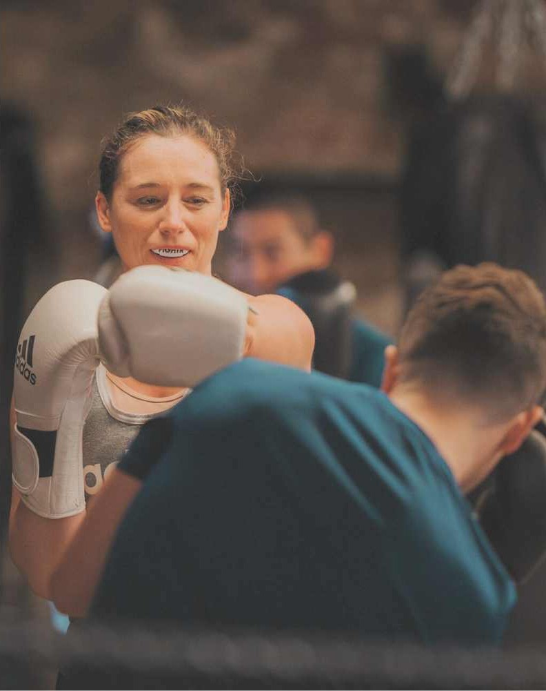 Member practicing boxing in small, achievable steps with coach guidance at FighterFit gym in London.